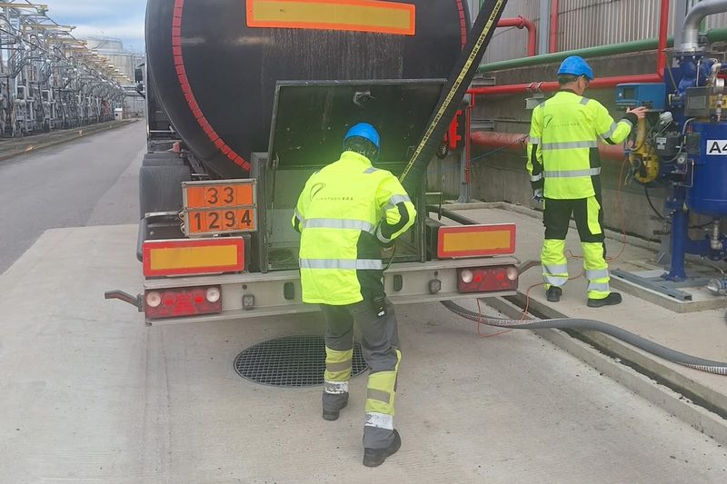 Two Liwathon E.O.S. operators connect a road tanker at the truck loading gantry.